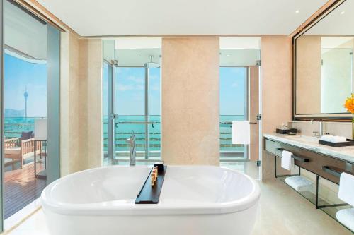 珠海珠海华发喜来登酒店的带阳台的浴室内设有一个大型白色浴缸