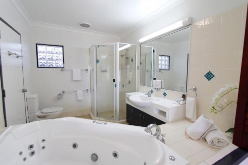 洛坎普顿咖啡馆公寓汽车旅馆的带浴缸、两个盥洗盆和淋浴的浴室。