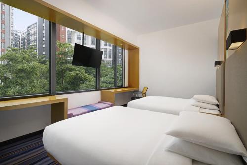 广州Aloft Guangzhou University Park的酒店客房设有两张床和一台平面电视。