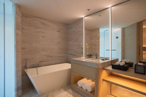 深圳深圳彭年万丽酒店的带浴缸、水槽和镜子的浴室