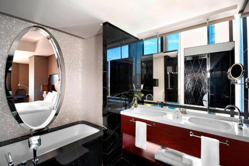 天津天津瑞吉金融街酒店的浴室设有镜子、浴缸和水槽