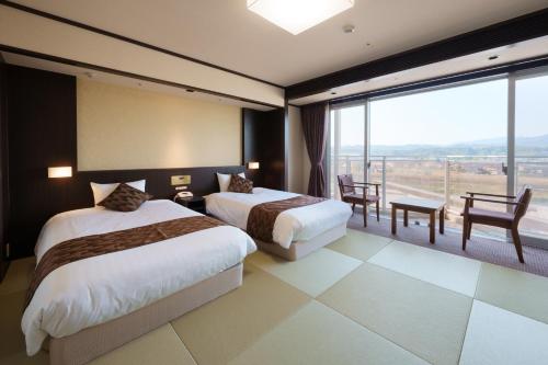 日田市Hita Tenryosui no Yado的酒店客房设有两张床和一个阳台。