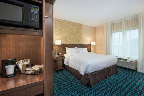 代顿Fairfield Inn & Suites by Marriott Dayton的配有一张床和一台平面电视的酒店客房