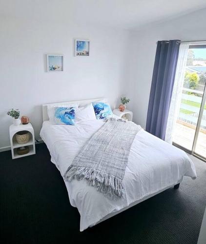 圣雷莫San Remo Coastal Apartment的卧室内的一张白色床,设有窗户