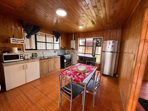 卡斯特鲁Hostal Magia Chilota的厨房配有桌椅和冰箱。
