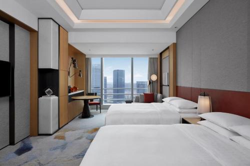 广州Sheraton Guangzhou Panyu的酒店客房设有两张床和一个阳台。
