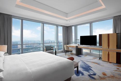 广州Sheraton Guangzhou Panyu的酒店客房设有一张床、一张书桌和窗户。