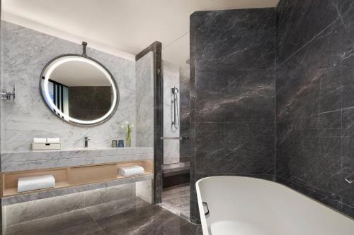 溧阳溧阳万豪酒店的带浴缸和镜子的浴室