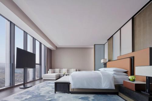 溧阳溧阳万豪酒店的一间酒店客房,配有一张床和一台电视