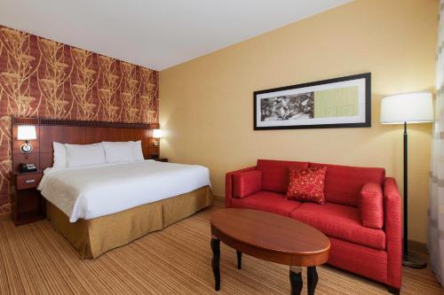 绍姆堡芝加哥绍姆堡/伍德菲尔德购物中心万怡酒店的酒店客房,配有一张床和一张红色的沙发