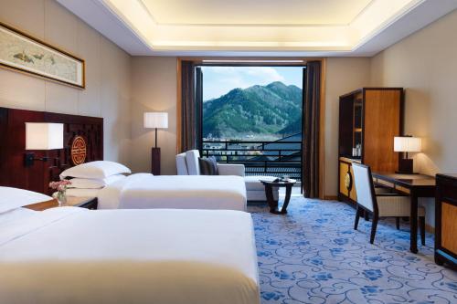 五台五台山万豪酒店的酒店客房设有四张床和窗户。
