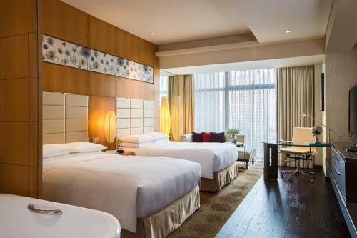 上海上海明捷万丽酒店的酒店客房配有两张床和一张书桌