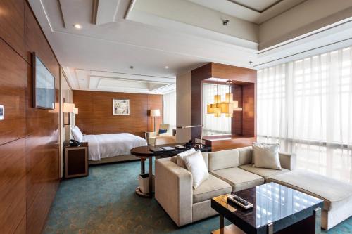 郑州郑州绿地JW万豪酒店的酒店客房设有一张沙发和一张床