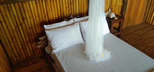 TanoPombero lodge的一间卧室配有带白色床单和枕头的床。