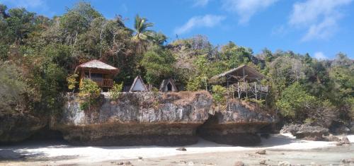 TanoPombero lodge的海滩上岩石上的小屋