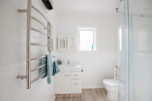 普纳凯基Cliffscapes的白色的浴室设有卫生间和水槽。