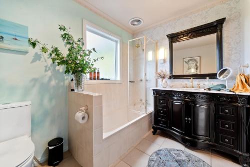 莱伊Ourania Luxury Villa with unforgettable sea views的带浴缸、水槽和镜子的浴室