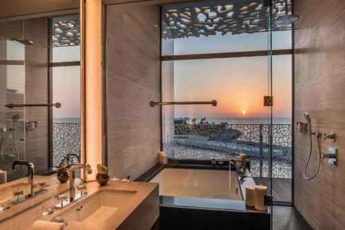 迪拜迪拜宝格丽度假村的带浴缸的浴室和大窗户