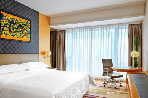 广州广州东圃福朋喜来登的配有床、椅子和桌子的酒店客房