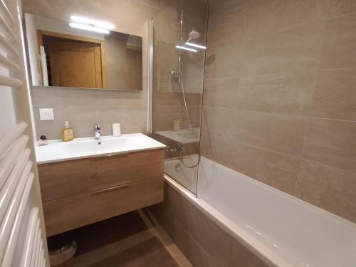 瓦尔莫雷尔Appartement Valmorel, 3 pièces, 5 personnes - FR-1-356-422的浴室配有水槽、淋浴和浴缸。