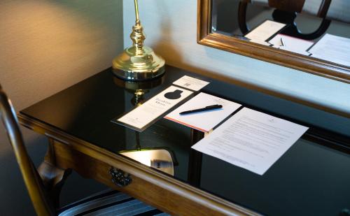 布里斯班斯坦福布里斯班广场酒店的一张桌子,上面有台灯和笔,上面有纸