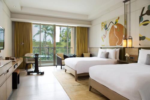 三亚三亚海棠湾万丽度假酒店的酒店客房配有两张床和一张书桌