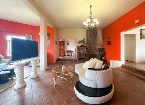 DensainagarTarkshay Hospitality的客厅设有橙色墙壁和电视