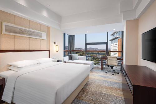 无锡无锡鲁能万怡酒店的酒店客房设有一张大床和一张书桌。