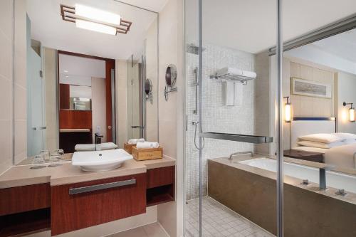 无锡无锡鲁能万怡酒店的浴室配有水槽、淋浴和浴缸。