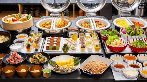 大阪Shizutetsu Hotel Prezio Osaka Shinsaibashi的自助餐,餐桌上有许多不同类型的食物