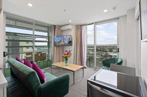 奥克兰曼努考/奥克兰机场近邻公寓的客厅配有沙发、椅子和电视