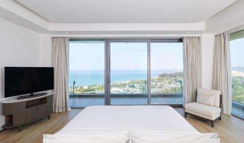 陵水海南蓝湾绿城威斯汀度假酒店（180°全海景客房）的一间卧室配有一张大床和电视