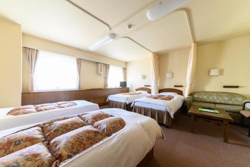 札幌札幌国际青年旅馆的酒店客房,设有三张床和一张沙发
