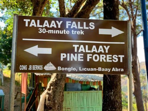 BanguedLayugan garden resort bucay abra的树上带有箭头的棕色标志