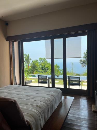 圣吉吉本哲龙目岛酒店的一间卧室设有一张床和一个大窗户