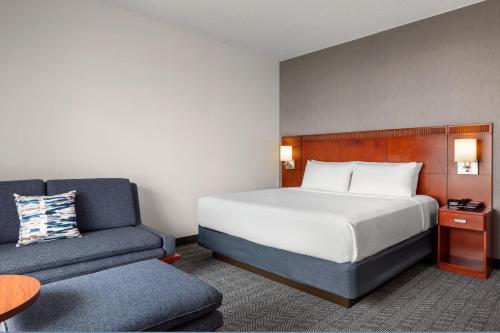 Mendota Heights明尼阿波利斯-圣保罗机场万怡酒店的配有一张床和一把椅子的酒店客房