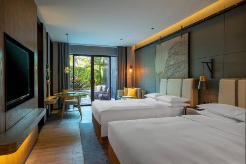 厦门厦门万丽酒店的酒店客房设有三张床和电视。