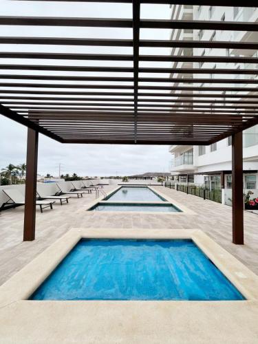 萨利纳斯Chipipe Salinas的一座带大屋顶的建筑中的游泳池