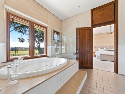 Metricup福雷斯特莱斯小木屋和小屋乡村民宿的带浴缸的大浴室和卧室
