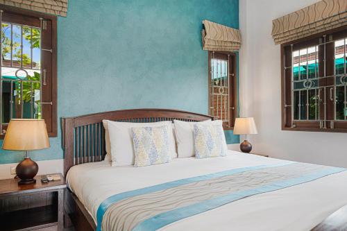 拉迈MyVillage Lamai的卧室内的一张床位,卧室拥有蓝色的墙壁和窗户