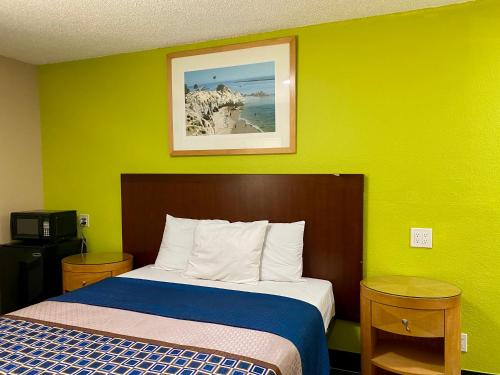 洛杉矶4 Star Motel的绿色墙壁间的一张床位