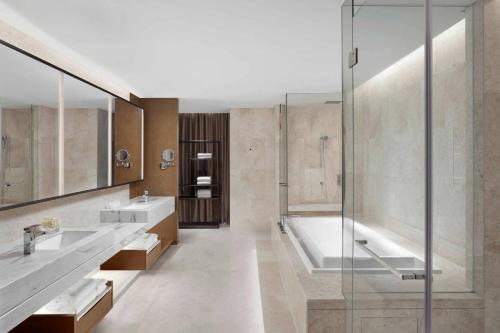 嘉兴嘉兴万豪酒店的浴室配有2个盥洗盆、浴缸和淋浴。