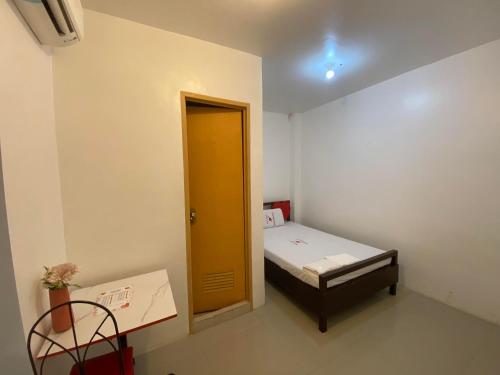 MaribagoWJV INN MARIBAG0的小房间,设有床和黄色门