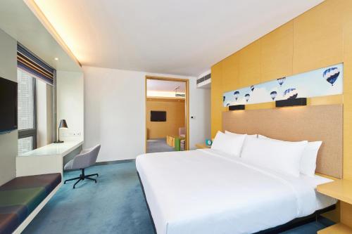 郑州郑州上街雅乐轩酒店 的酒店客房设有一张白色大床和一张书桌