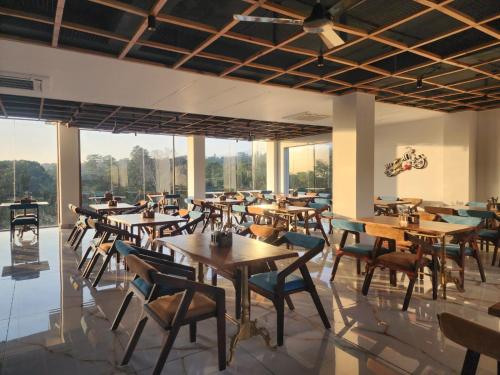 达兰萨拉Portola Hotel By Parkside的餐厅设有桌椅和大窗户。
