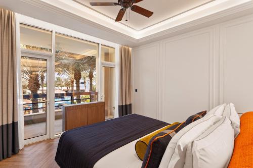 阿吉曼Ajman Hotel by Blazon Hotels的一间卧室配有一张床和吊扇
