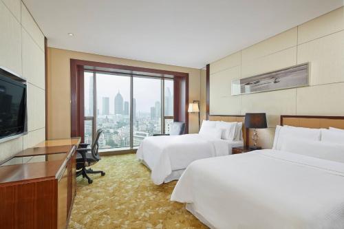 天津天津君隆威斯汀酒店的酒店客房设有两张床和一台平面电视。