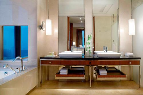天津天津君隆威斯汀酒店的一间带两个盥洗盆和大镜子的浴室