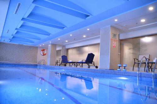伊斯兰堡伊斯兰堡万豪酒店 的一个带椅子和桌子的大型游泳池