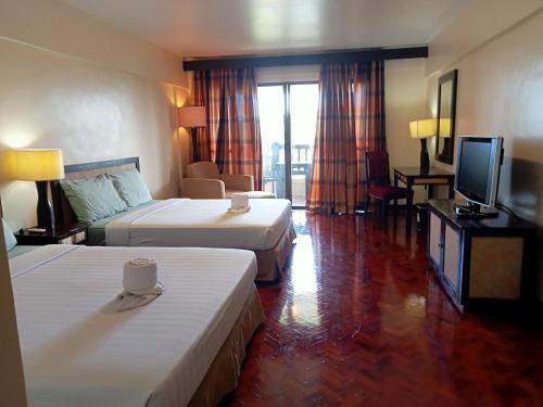 长滩岛Keira 208, Alta Vista De Boracay的酒店客房设有两张床和一台平面电视。